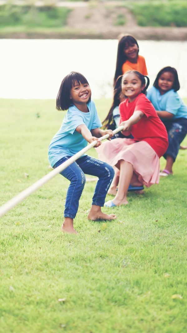 Children group playing tug of war at the park